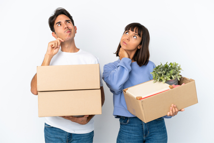 Couple s'interrogeant avec cartons déménagement dans les mains